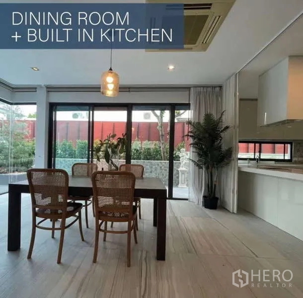 独立式住宅 出售在Khlong Toei, Bangkok - 餐厅设四把椅子、吊灯与整面推拉玻璃门。