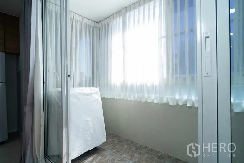 คอนโด ขายในWatthana, Bangkok - มุมซักล้างพร้อมเครื่องซักผ้า หลังประตูกระจกและม่านโปร่ง