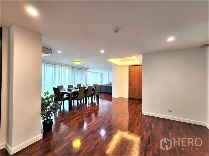 公寓 出租在Bang Rak, Bangkok - 入口走廊通向餐区，整排窗户、嵌灯与光亮木地板。