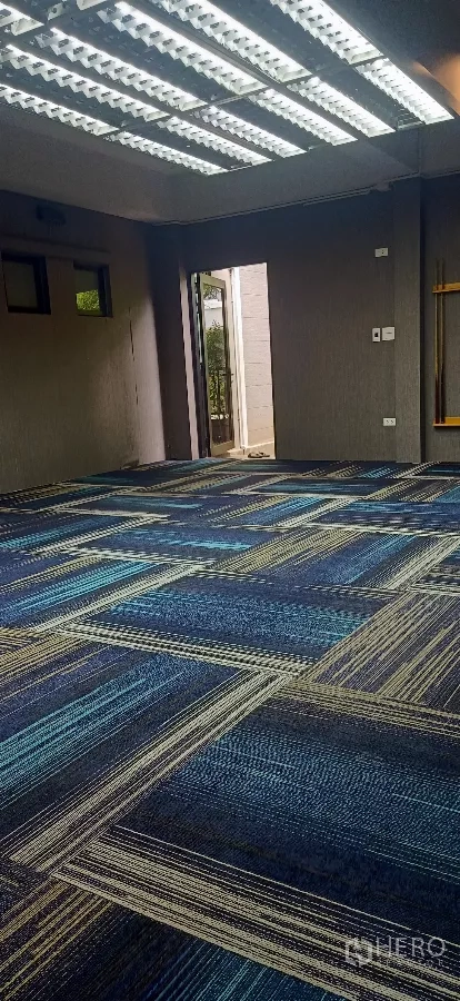 บ้าน ให้เช่าหรือขายในKhan Na Yao, Bangkok - ห้องอเนกประสงค์ขนาดใหญ่ ปูพรมลายสีน้ำเงิน ไฟเส้นบนเพดานและประตูออกลาน