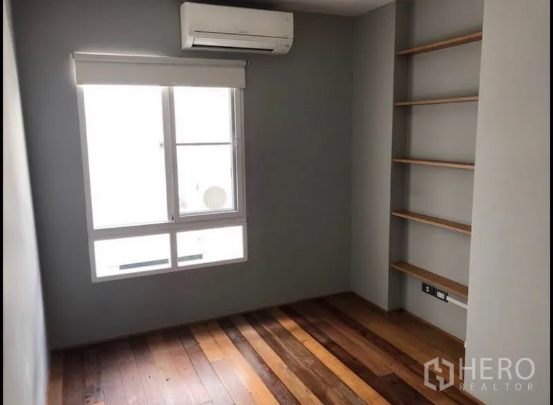 联排别墅 出售在Wang Thonglang, Bangkok - 卧室配空调与采光窗，墙面开放式层架和木地板。