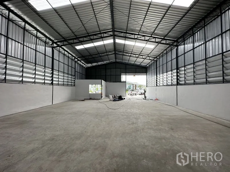 คลังสินค้า ให้เช่าในLam Luk Ka, Pathum Thani - มองไปทางช่องโหลดขนาดกว้าง พื้นคอนกรีตเรียบและจุดบริการไฟฟ้ามองเห็นชัด