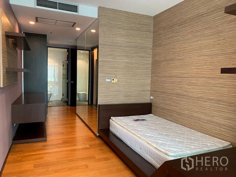 Condominium for rent - Bedroom with single bed frame, mirrored wardrobe, wood floors, and ensuite access.