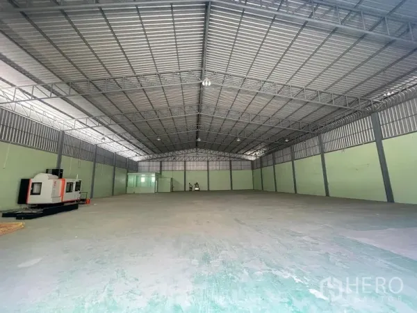 Warehouse for rent in Bang Phli, Samut Prakan - Spacious clear-span warehouse interior with steel truss roof, skylights, and concrete floor.