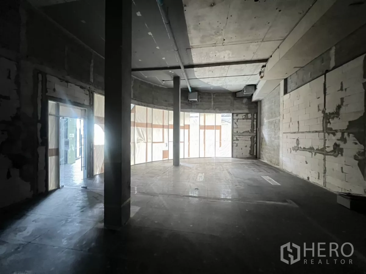 พื้นที่ขายปลีก ให้เช่าในSuan Luang, Bangkok - พื้นที่ร้านแบบโอเพนสเปซ เพดานสูง มีเสาโครงสร้างและประตูกระจกด้านข้างออกสู่ทางเดิน