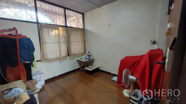 Townhouse for sale - Secondary bedroom with wood floors, high windows, and space for wardrobe or storage.