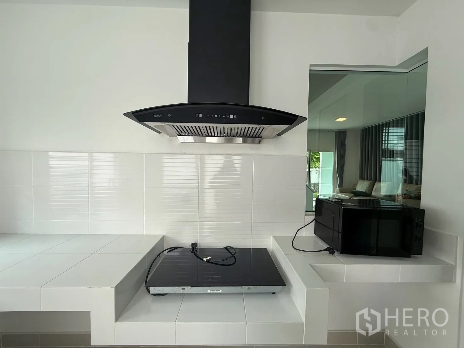 บ้านเดี่ยว for rent in Bang Phli, Samut Prakan - ภาพระยะใกล้เตาฮูดและเตาไฟฟ้าในครัว พร้อมชั้นวางไมโครเวฟ
