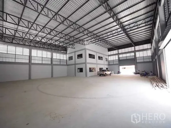 Warehouse for rent or sale in Krathum Baen, Samut Sakhon - Spacious warehouse hall with steel truss roof, internal office block and wide loading openings.