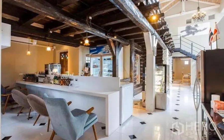 พื้นที่ขายปลีก ให้เช่าในKhlong Toei, Bangkok - ภายในร้านเพดานสูง มีเคาน์เตอร์บาร์สีขาว คานไม้สีเข้ม และไฟห้อย