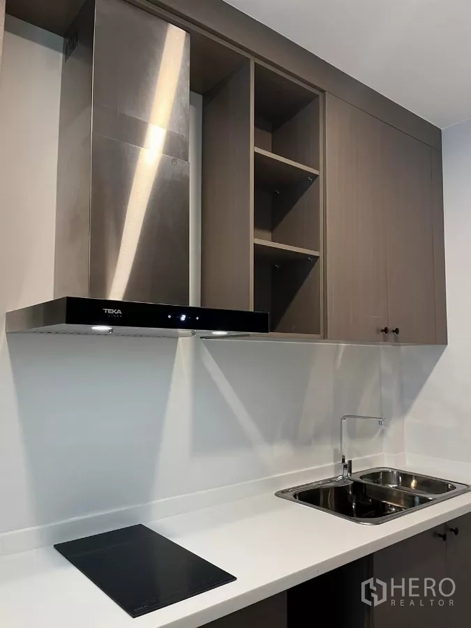 Detached House for rent or sale in Bang Phli, Samut Prakan - Close-up of the modern kitchen with induction hob, stainless hood, and double sink.
