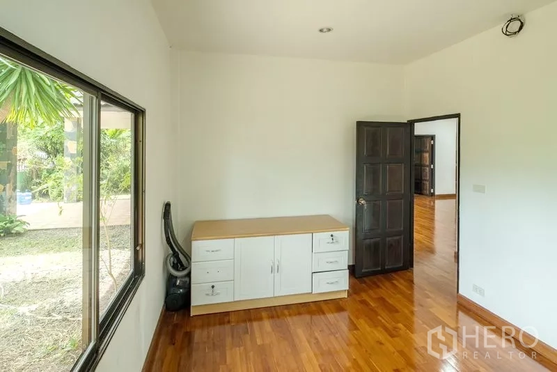 Detached House for sale in Bang Lamung, Chon Buri - Secondary bedroom or study with a large window looking onto the garden.