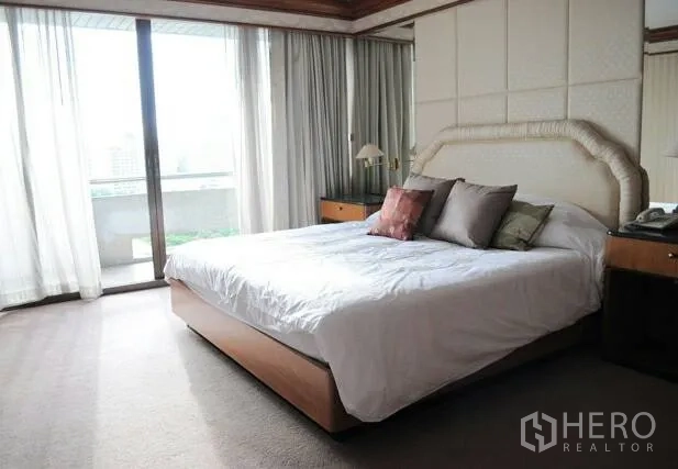 คอนโด ขายในPathum Wan, Bangkok - ห้องนอนสว่าง ประตูบานกระจกออกระเบียง พร้อมผ้าม่านและหัวเตียงบุนวม