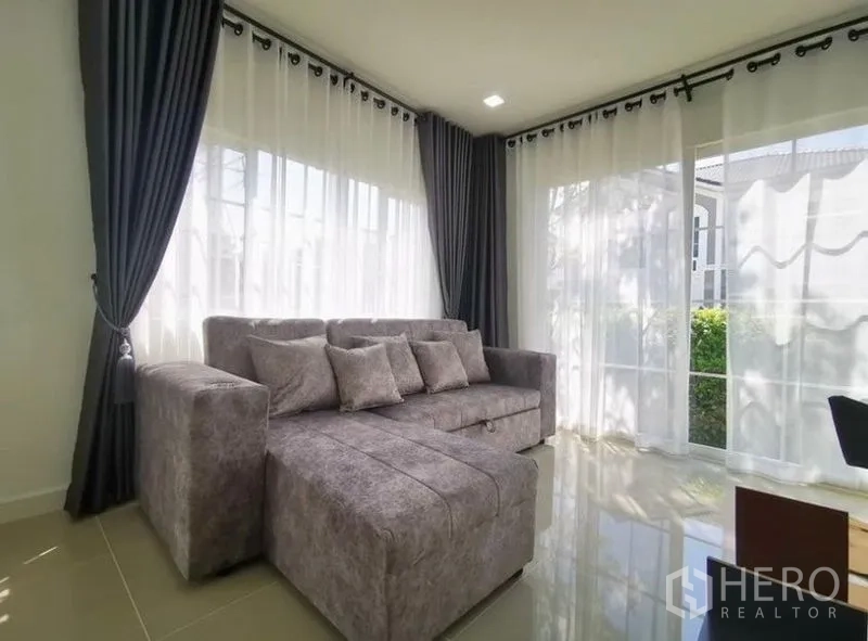 独立式住宅 出租 - 阳光客厅，灰色转角沙发与轻薄窗帘。