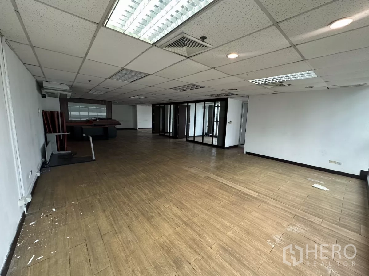 Office Space for rent in Watthana, Bangkok - Spacious office floor with centralized air vents, mixed ceiling lights, and multiple glass-partitioned rooms in the back.