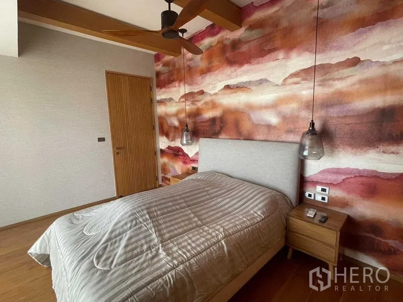 公寓 出租或出售在Watthana, Bangkok - 客卧带暖色抽象壁画、吊扇与床头柜