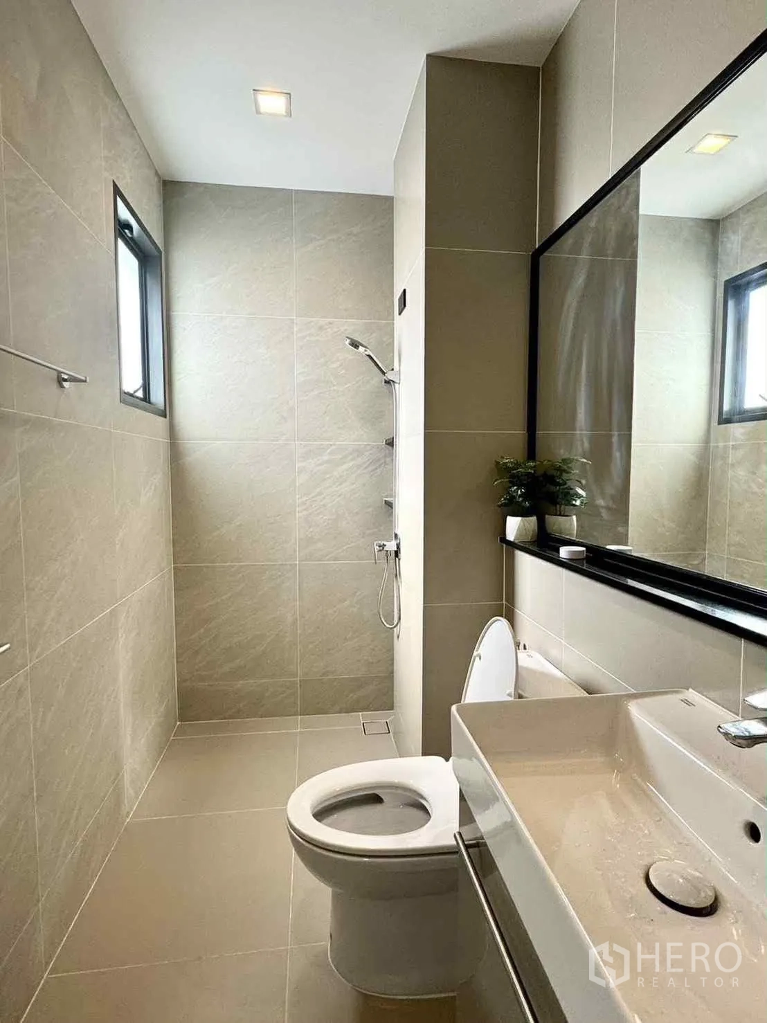 Detached House for rent in Bang Phli, Samut Prakan - Contemporary bathroom with walk-in shower, toilet, large mirror and beige tiles.