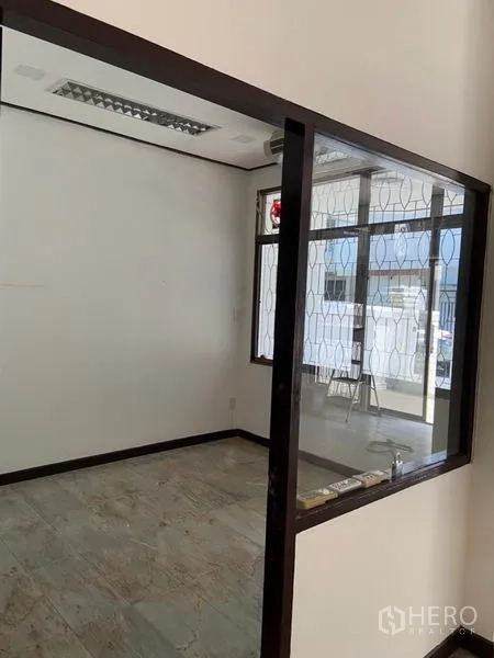 ทาวน์เฮาส์ ให้เช่าในKhlong Toei, Bangkok - ห้องขนาดเล็กกั้นกระจก ผนังสีขาว พื้นกระเบื้อง และหน้าต่างติดเหล็กดัดลาย