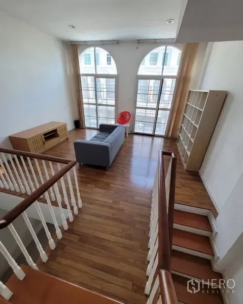 联排别墅 出售在Bang Kapi, Bangkok - 楼上起居区，木地板，超高拱形落地窗与楼梯平台。