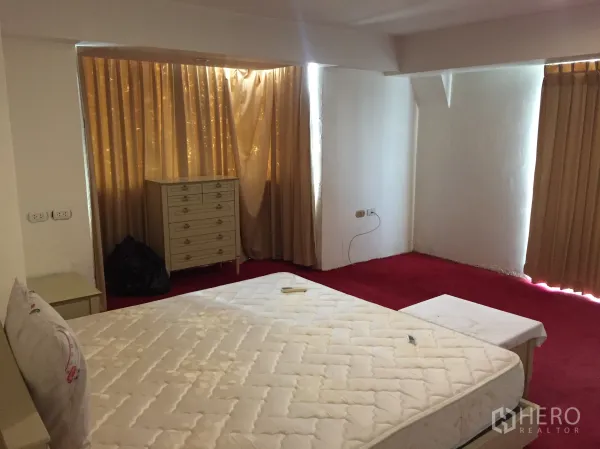 公寓 出租在Khlong Toei, Bangkok - 次卧铺红色地毯，配米色窗帘和抽屉柜