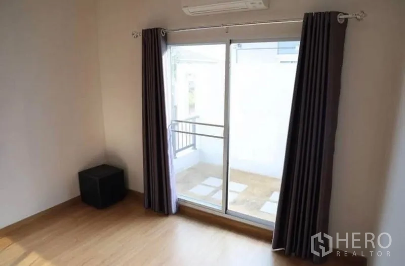 Detached House for rent in Suan Luang, Bangkok - Third bedroom with wood floors and a sliding door to a small balcony.