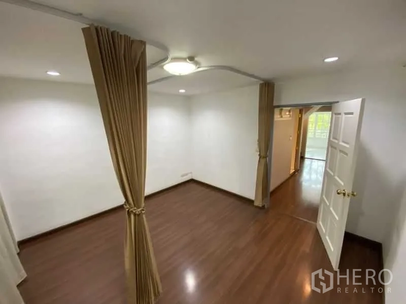 店屋 出租或出售在Watthana, Bangkok - 温馨木地板房，配窗帘与顶灯，连接主空间。