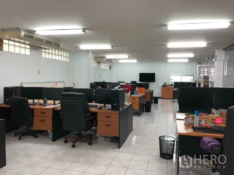 Warehouse for rent in Chatuchak, Bangkok - Large office floor featuring multiple workstations under fluorescent lighting.