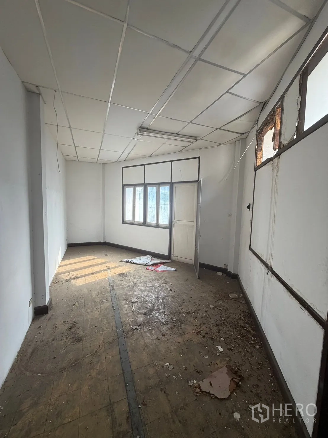 Shophouse for rent in Watthana, Bangkok - Simple upper room with a window and suspended ceiling in basic condition.