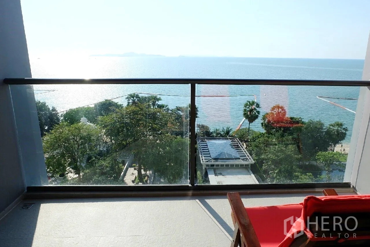 Condominium for rent or sale in Bang Lamung, Chon Buri - Private balcony with glass railing overlooking trees, pool pavilion and the open sea.