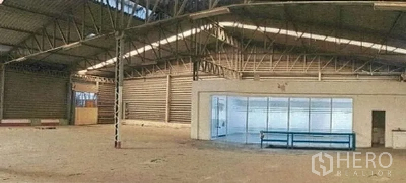 Warehouse for rent in Phra Pradaeng, Samut Prakan - Spacious warehouse hall with steel truss roof and an enclosed glass office.