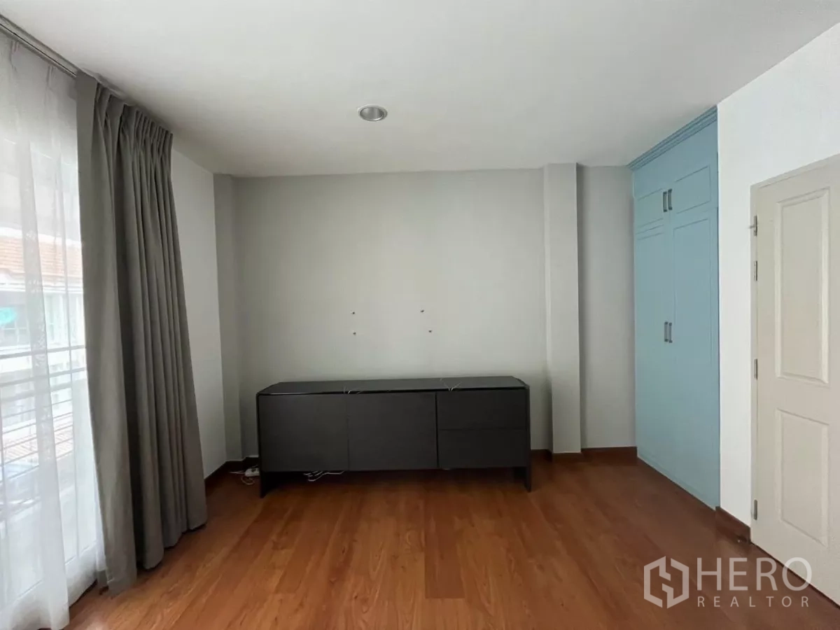 Townhouse for rent in Chom Thong, Bangkok - Spacious bedroom with built-in cabinet, sideboard and balcony curtain.