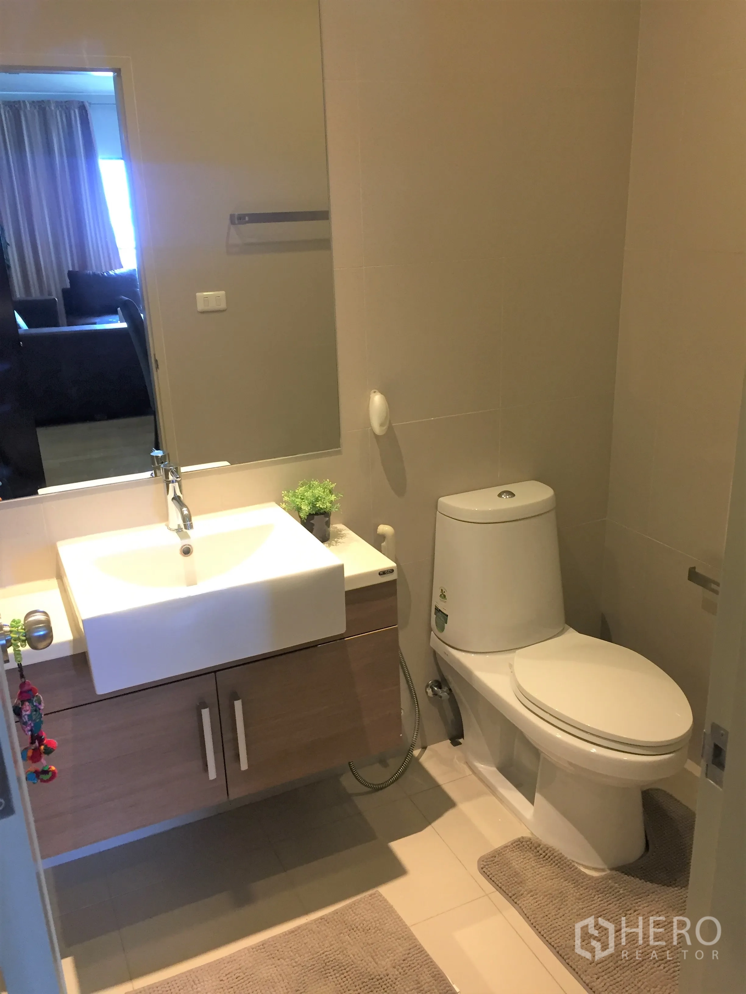Condominium for rent in Watthana, Bangkok - Second bathroom with white basin, wooden cabinet storage, and clean tiled flooring.