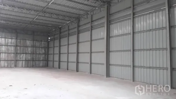 คลังสินค้า ให้เช่าในLat Phrao, Bangkok - มุมมองผนังด้านข้างของโกดัง ผนังเมทัลชีท โครงหลังคา และพื้นคอนกรีตโล่งสำหรับจัดเก็บสินค้า