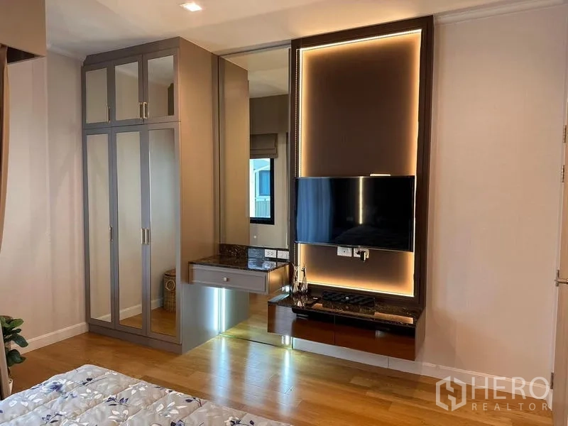 独立式住宅 出租在Prawet, Bangkok - 卧室带灯带电视墙、内置衣柜与木地板。