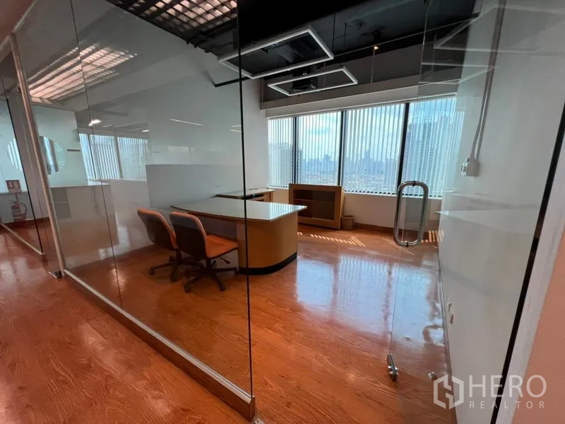 Office Space for rent in Khlong Toei, Bangkok - Private office behind a glass partition with desk, chairs and floor-to-ceiling windows.