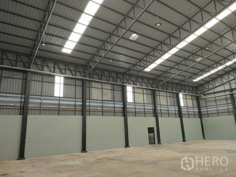 工厂 出租在Ban Phaeo, Samut Sakhon - 仓库墙体，成排钢柱与屋顶采光带。