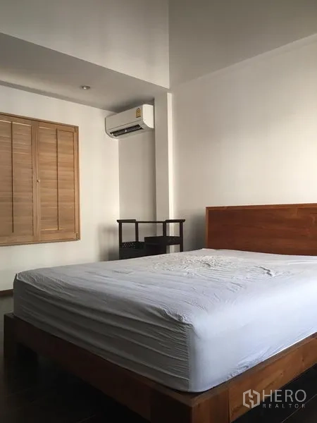 ทาวน์เฮาส์ ให้เช่าในKhlong Toei, Bangkok - ห้องนอนเตียงไม้ เครื่องปรับอากาศ และบานหน้าต่างบานเกล็ด