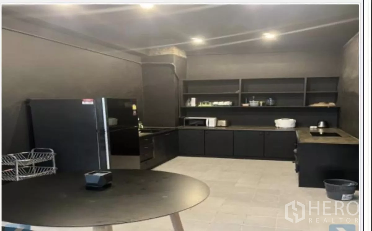 Home Office for rent in Wang Thonglang, Bangkok - Fitted kitchen with black cabinetry, open shelves, and appliances.
