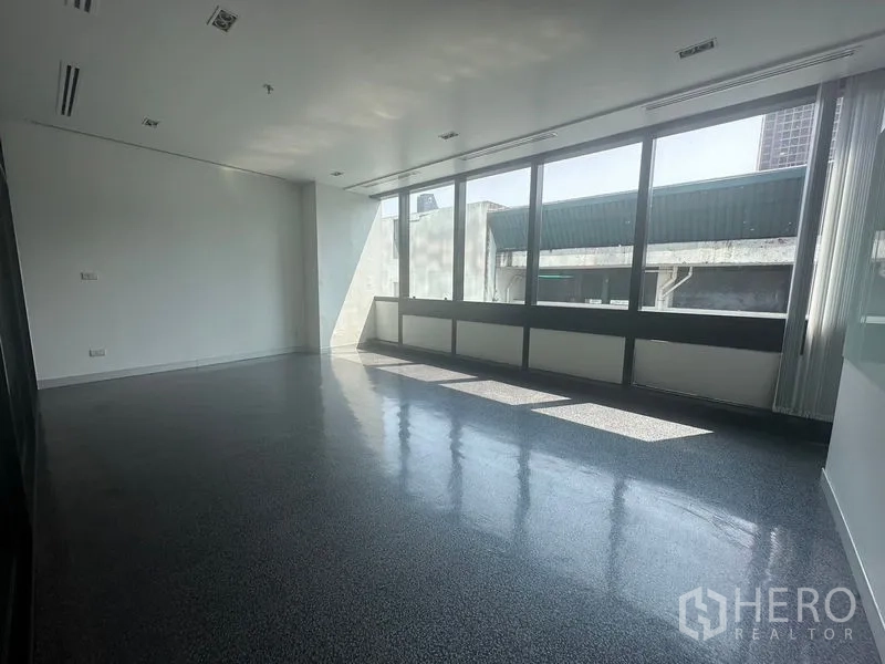Office Space for rent in Khlong Toei, Bangkok - Bright office room with wall-to-wall windows and glossy floors.