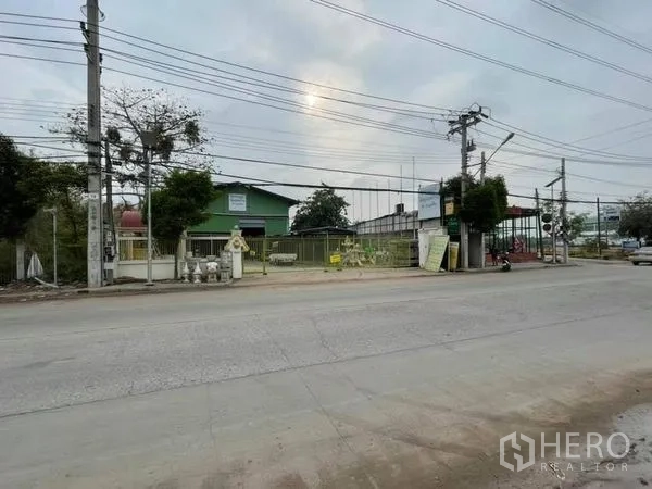 Warehouse for rent in Phra Samut Chedi, Samut Prakan - Street frontage view of gated warehouse complex with main road access.