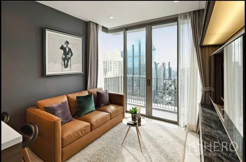 Condominium for rent in Bang Rak, Bangkok - Living room with balcony doors, soft rug and skyline view next to a built-in TV wall.