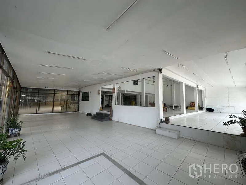 Warehouse for rent in Pak Kret, Nonthaburi - Flexible showroom and display area with raised platforms, tiles, and glass partitions.