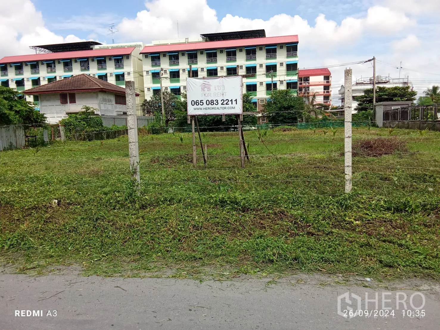 Land for rent in Khan Na Yao, Bangkok - Fenced grassy land plot with a for rent sign and low-rise apartments behind in Khan Na Yao.