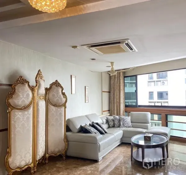 คอนโด ให้เช่าในKhlong Toei, Bangkok - มุมนั่งเล่นโซฟาเข้ามุม ฉากกั้นลายหรูสีทอง และหน้าต่างบานกว้าง