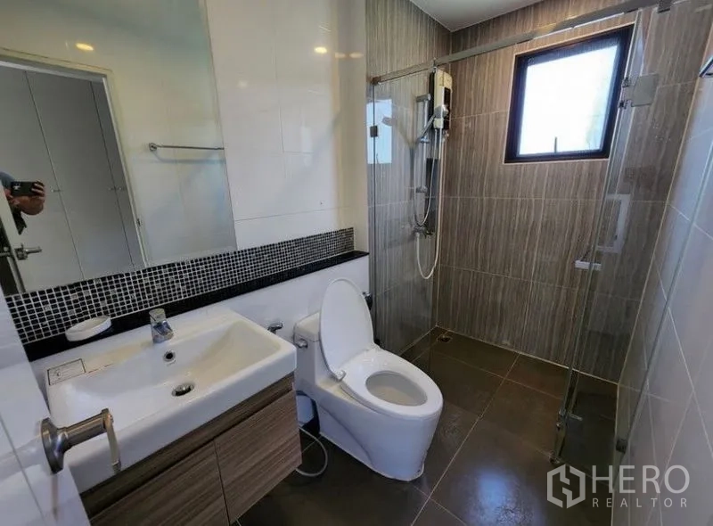 บ้าน ให้เช่าในPrawet, Bangkok - ห้องน้ำสมัยใหม่พร้อมฉากกั้นอาบน้ำกระจก อ่างล้างหน้า และผนังกระเบื้อง