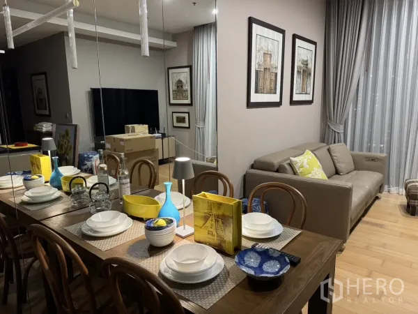 คอนโด ให้เช่าในWatthana, Bangkok - มุมรับประทานอาหารจัดจานชามครบ ถัดไปเป็นโซฟาและทีวี ใต้ไฟแขวนดีไซน์โมเดิร์น