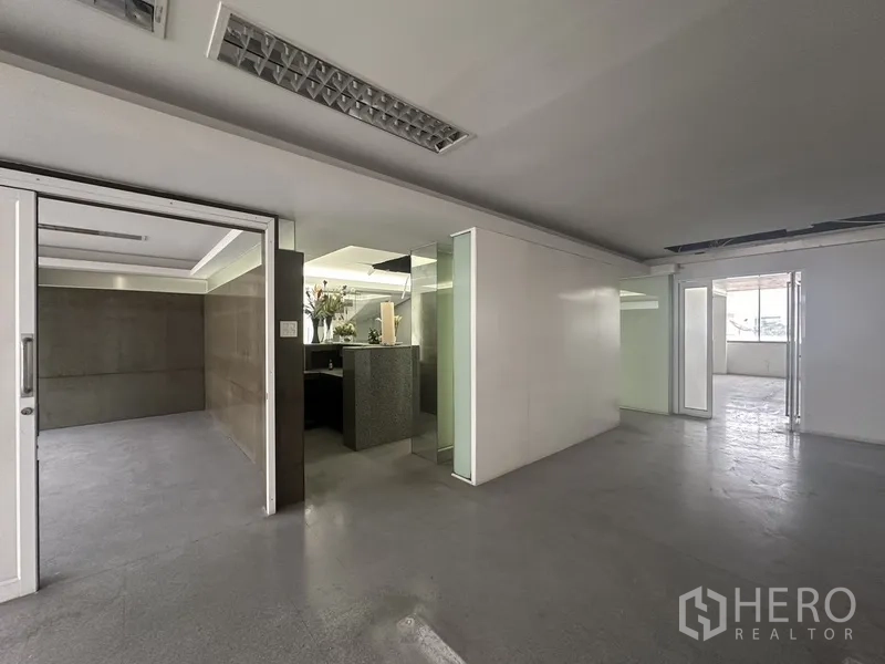 Office Space for rent in Khlong Toei, Bangkok - Reception nook with built-in counter, sliding doors and frosted glass panels.