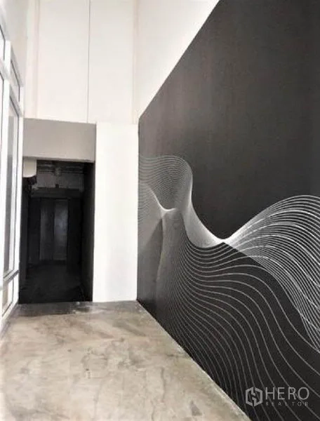 พื้นที่ขายปลีก ให้เช่าในPhaya Thai, Bangkok - โถงทางเดินของร้านพร้อมผนังสีดำลายกราฟิกและพื้นคอนกรีต ข้างผนังกระจก