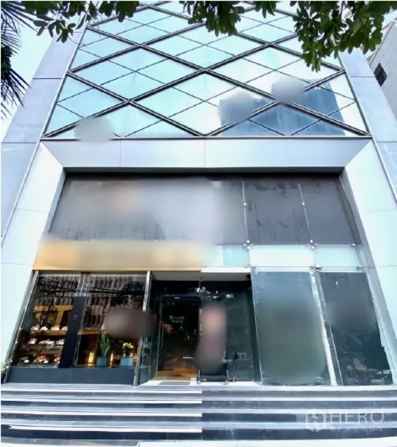 零售空间 出租在Watthana, Bangkok - 现代玻璃幕墙商业大楼入口，宽阔台阶与双层挑高店面。