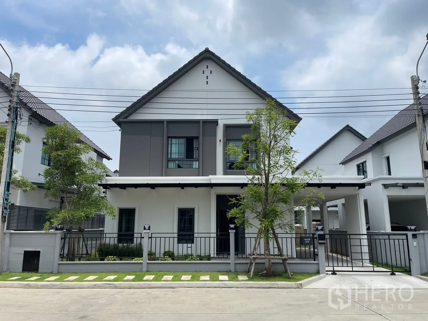 Detached House for rent in Bang Phli, Samut Prakan - Contemporary two-storey detached house exterior with gable roof, front lawn, fence, and covered carport.
