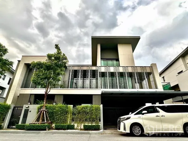 Detached House for sale in Saphan Sung, Bangkok - Modern detached house facade with tall metal screens, gated entry and carport with a white MPV at the front.